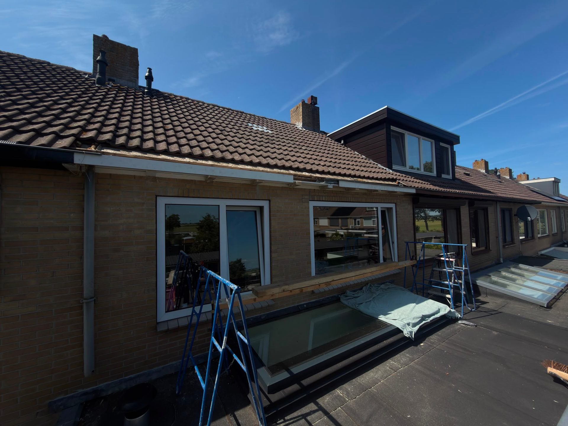 Vernieuwde dakrand en boeiboorden van een woning tijdens buitenschilderwerk in Limmen